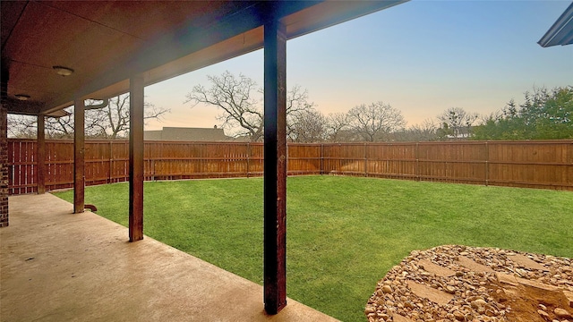 yard at dusk featuring a patio