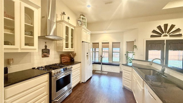 kitchen featuring sink, white appliances, tasteful backsplash, dark hardwood / wood-style flooring, and wall chimney exhaust hood