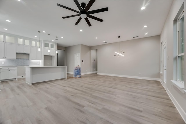 unfurnished living room featuring ceiling fan and light hardwood / wood-style floors