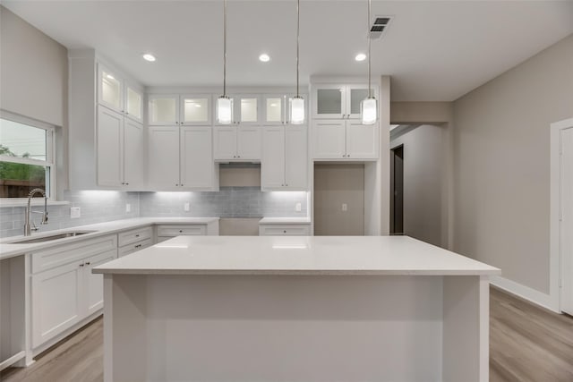 kitchen featuring a center island, sink, and white cabinets