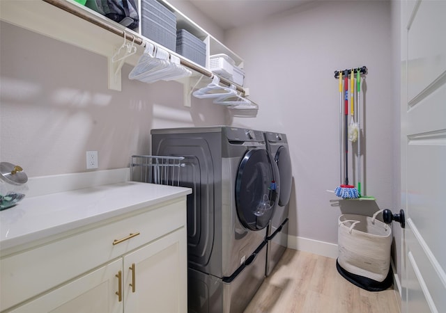 laundry room featuring washing machine and dryer and light hardwood / wood-style flooring