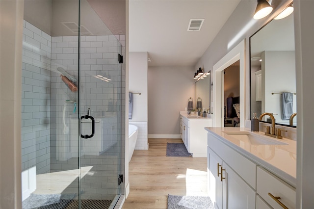 bathroom featuring vanity, wood-type flooring, and independent shower and bath