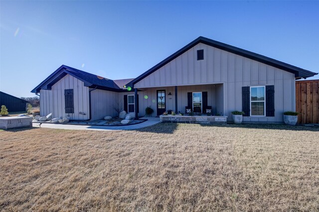 rear view of property featuring a lawn and a patio area