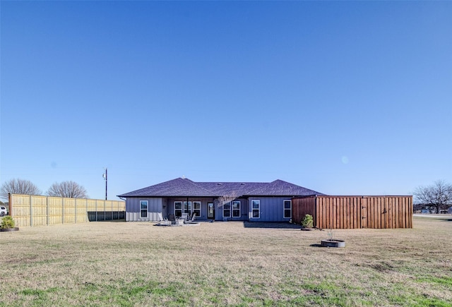 back of property featuring a yard and a fire pit