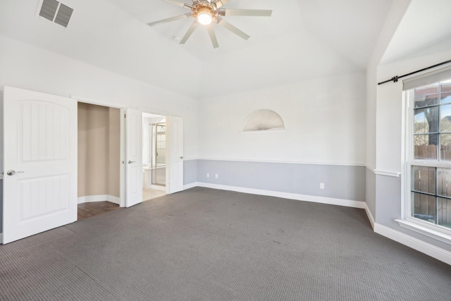 unfurnished room featuring ceiling fan, vaulted ceiling, and dark colored carpet