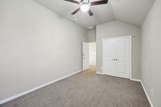 unfurnished bedroom featuring carpet flooring, a closet, vaulted ceiling, and ceiling fan