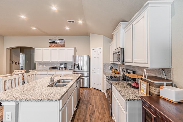 kitchen with sink, stainless steel appliances, white cabinets, and a center island with sink