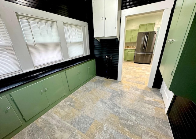 kitchen featuring stainless steel refrigerator and green cabinetry