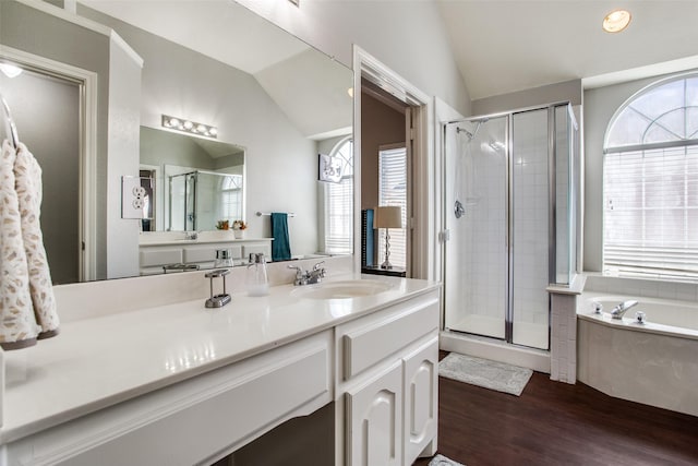 bathroom featuring hardwood / wood-style flooring, lofted ceiling, plus walk in shower, and vanity