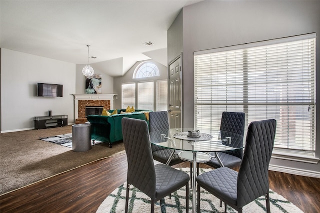 dining area featuring dark hardwood / wood-style flooring and vaulted ceiling