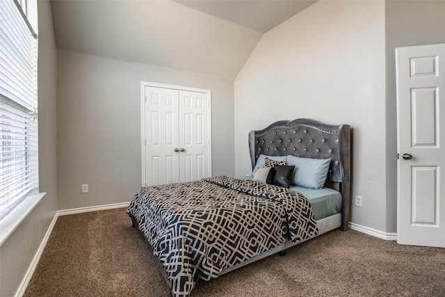 bedroom featuring lofted ceiling, dark carpet, and a closet