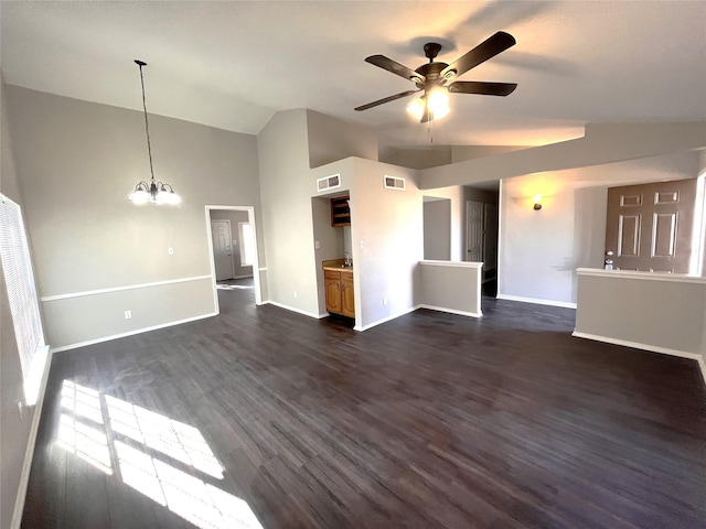 unfurnished living room with ceiling fan with notable chandelier, dark wood-type flooring, and high vaulted ceiling