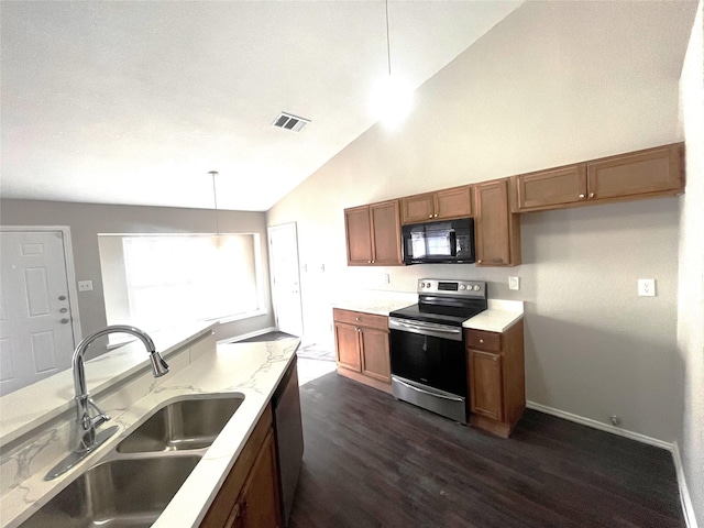 kitchen featuring dark wood-type flooring, sink, hanging light fixtures, appliances with stainless steel finishes, and light stone counters