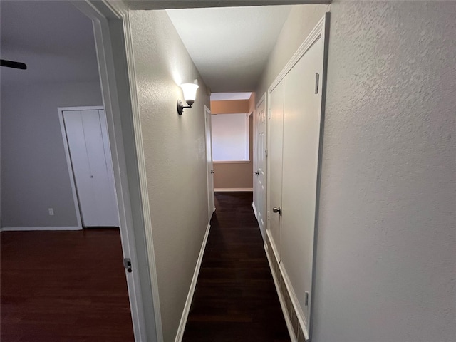 hallway with dark hardwood / wood-style flooring