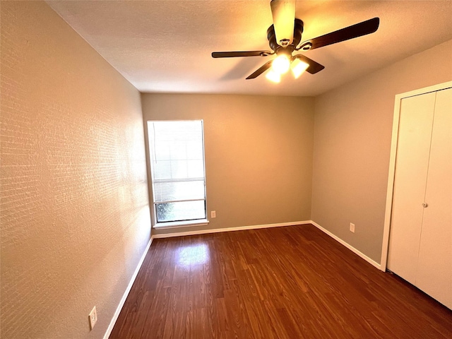 unfurnished bedroom with ceiling fan and dark hardwood / wood-style flooring