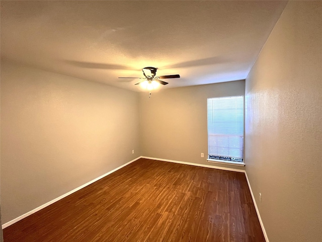 empty room featuring ceiling fan and dark hardwood / wood-style flooring