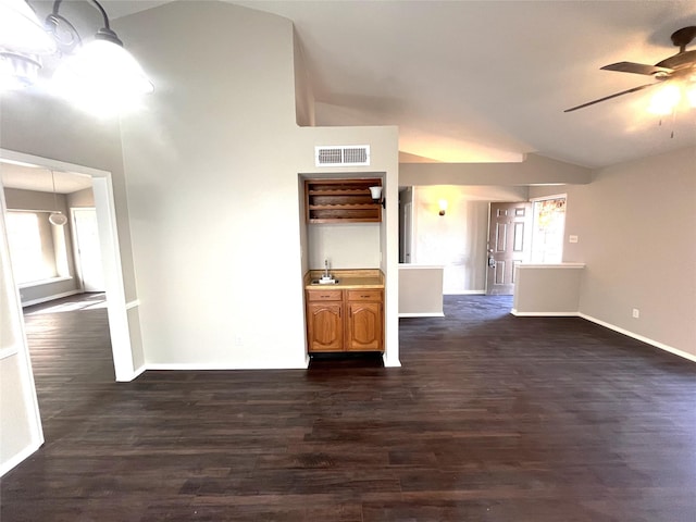 unfurnished living room with dark wood-type flooring, ceiling fan, and vaulted ceiling