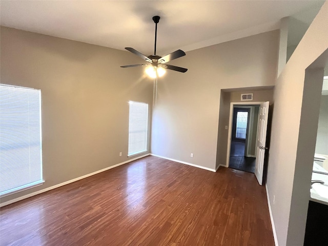 empty room with dark hardwood / wood-style flooring and ceiling fan