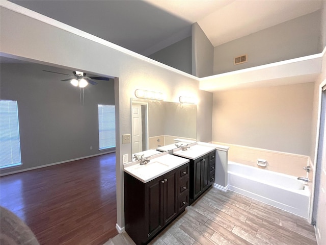 bathroom featuring a washtub, ceiling fan, wood-type flooring, and vanity