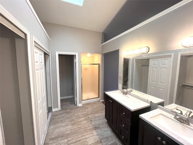 bathroom with a skylight, a shower, and vanity