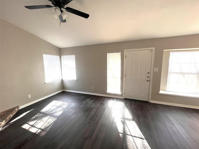 interior space featuring ceiling fan, dark wood-type flooring, and vaulted ceiling