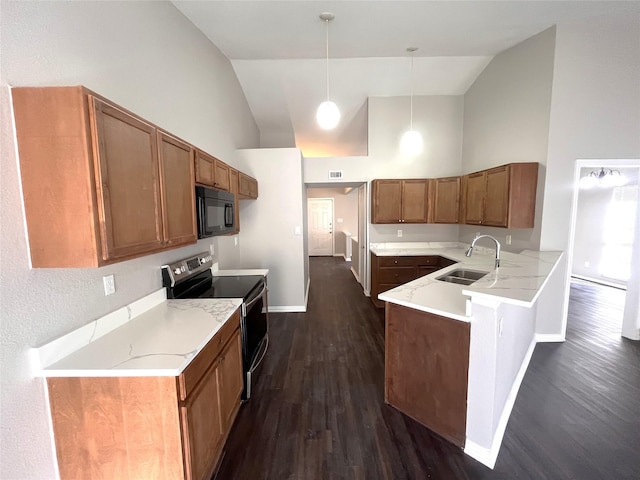 kitchen with kitchen peninsula, sink, black appliances, pendant lighting, and high vaulted ceiling