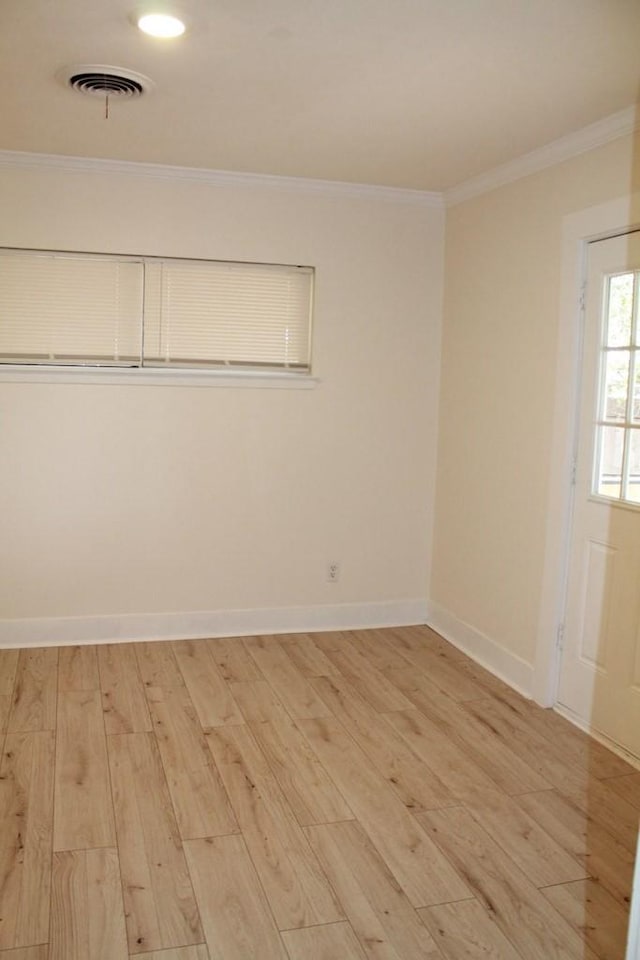 spare room featuring ornamental molding and light wood-type flooring