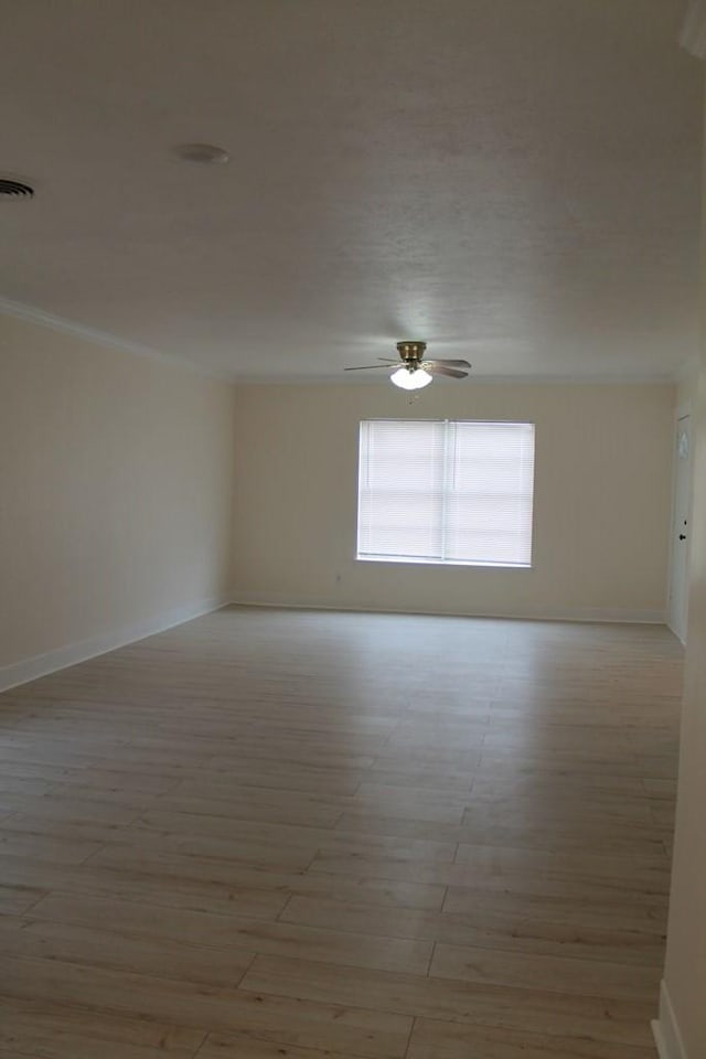 empty room featuring ornamental molding, light wood-type flooring, and ceiling fan