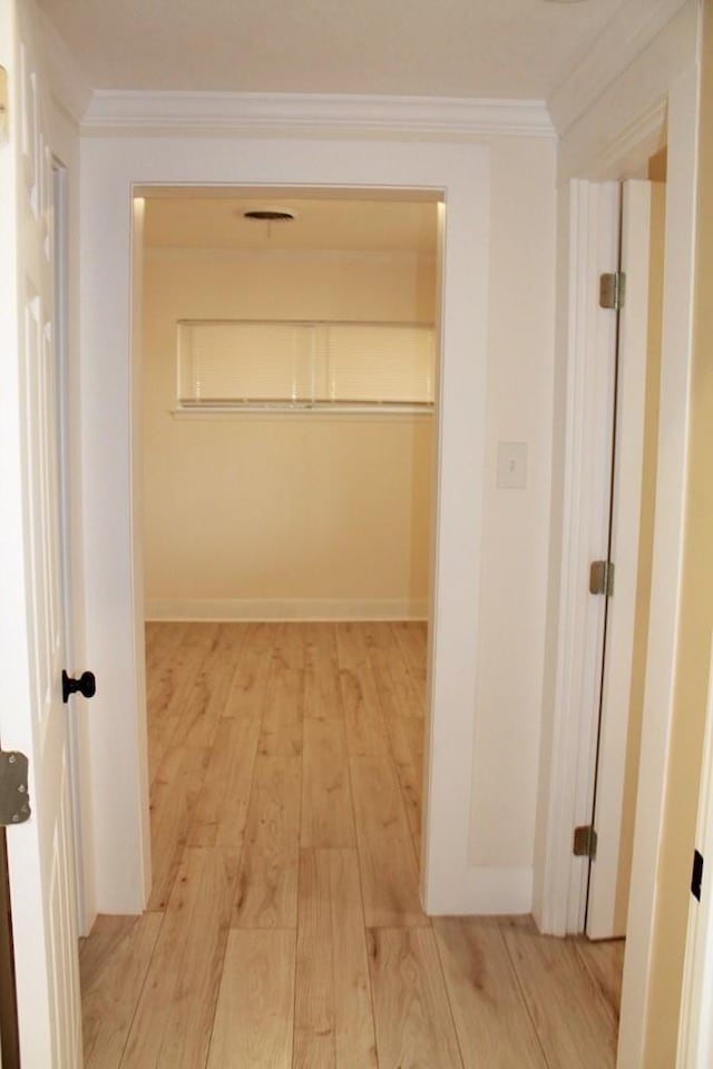 corridor with crown molding and light hardwood / wood-style floors