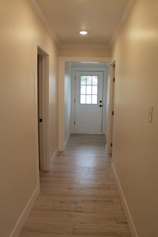 doorway to outside with crown molding and light hardwood / wood-style flooring