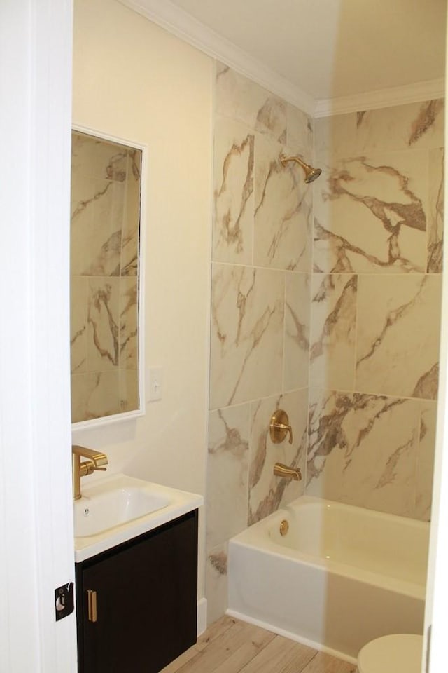 bathroom with crown molding, vanity, tiled shower / bath combo, and hardwood / wood-style floors