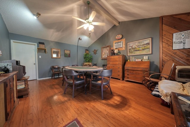 dining room with hardwood / wood-style flooring, vaulted ceiling with beams, ceiling fan, a textured ceiling, and heating unit