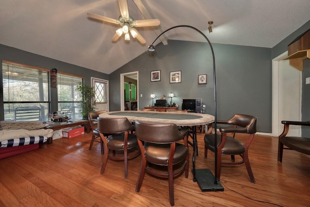 dining room with ceiling fan, vaulted ceiling, and light wood-type flooring