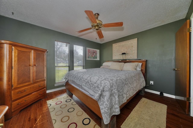 bedroom with ceiling fan, dark hardwood / wood-style floors, and a textured ceiling