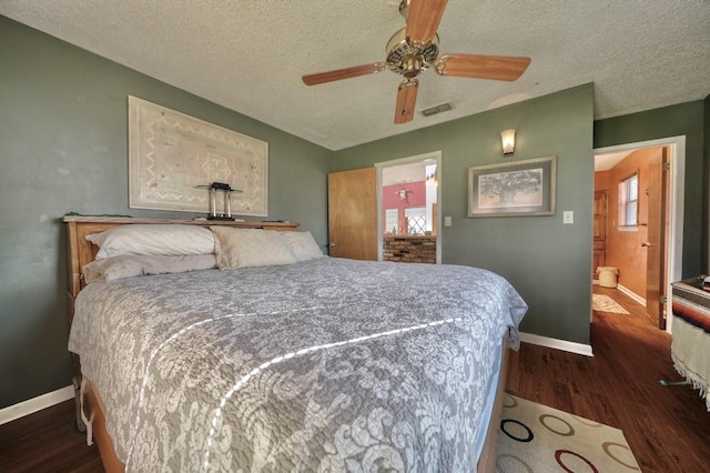 bedroom featuring a textured ceiling, connected bathroom, dark hardwood / wood-style floors, and ceiling fan