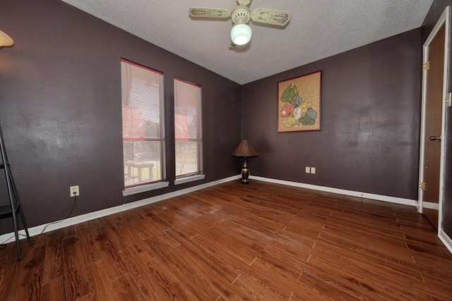 empty room with ceiling fan, wood-type flooring, and a textured ceiling