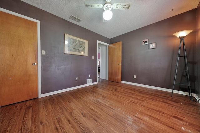 unfurnished bedroom with a textured ceiling and hardwood / wood-style flooring