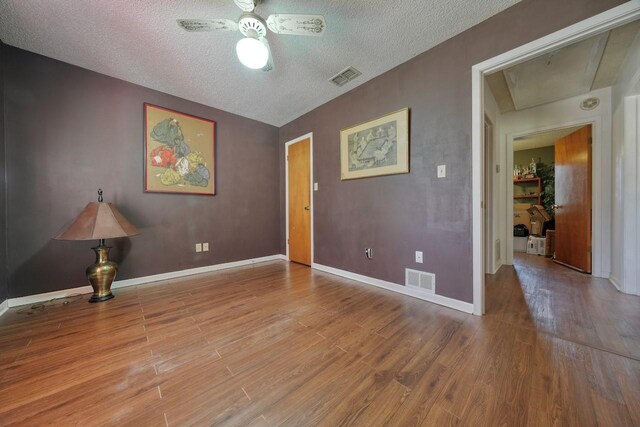 unfurnished room featuring a textured ceiling, light hardwood / wood-style floors, and ceiling fan