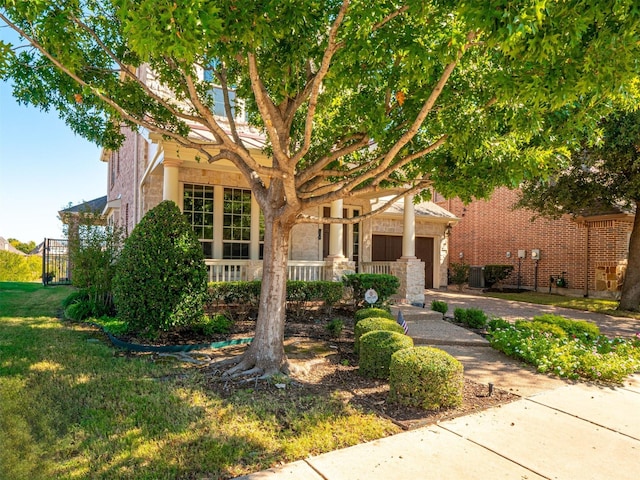 view of front of home with a garage, central AC, and a front yard