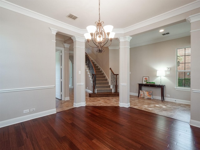 interior space featuring a chandelier, decorative columns, and crown molding