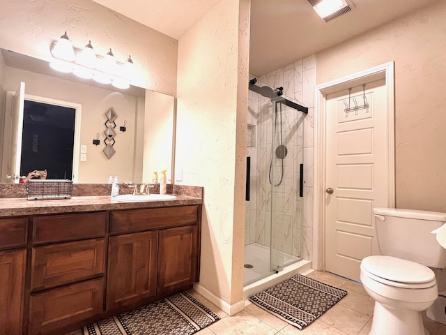 bathroom with toilet, vanity, tile patterned floors, and a shower with shower door