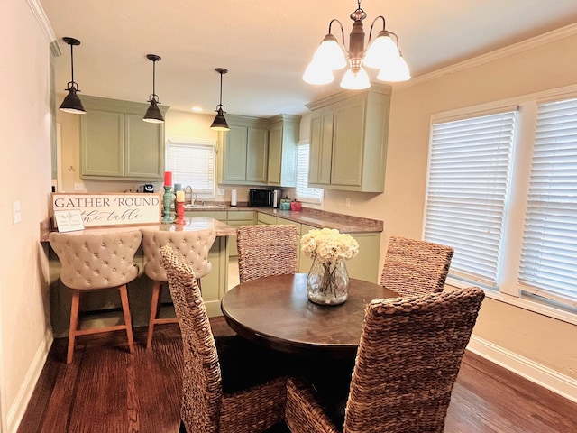 dining space with a chandelier, dark hardwood / wood-style floors, crown molding, and sink