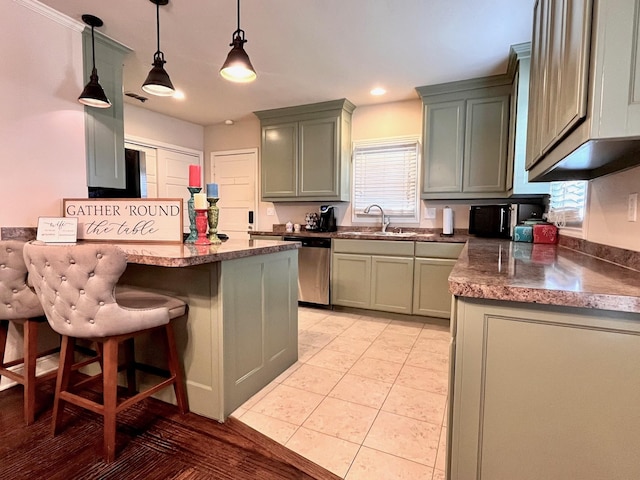 kitchen with a kitchen breakfast bar, stainless steel dishwasher, sink, light tile patterned floors, and decorative light fixtures