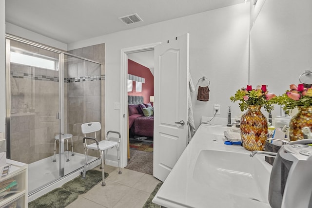 bathroom with tile patterned flooring, a shower with shower door, and sink