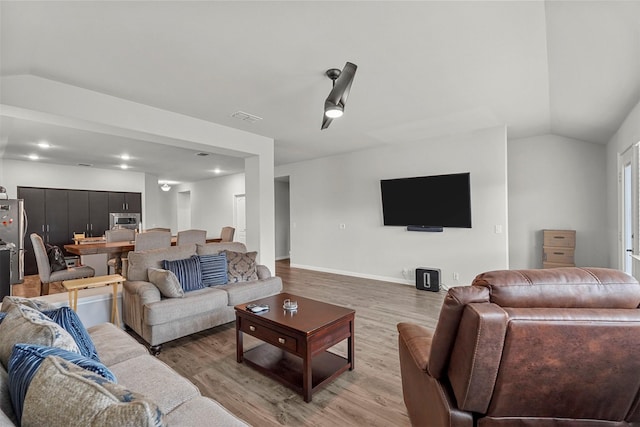 living room featuring light hardwood / wood-style flooring and lofted ceiling