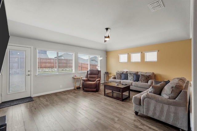 living room featuring hardwood / wood-style flooring and vaulted ceiling