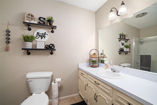 bathroom featuring tile patterned flooring, vanity, toilet, and a shower with shower door