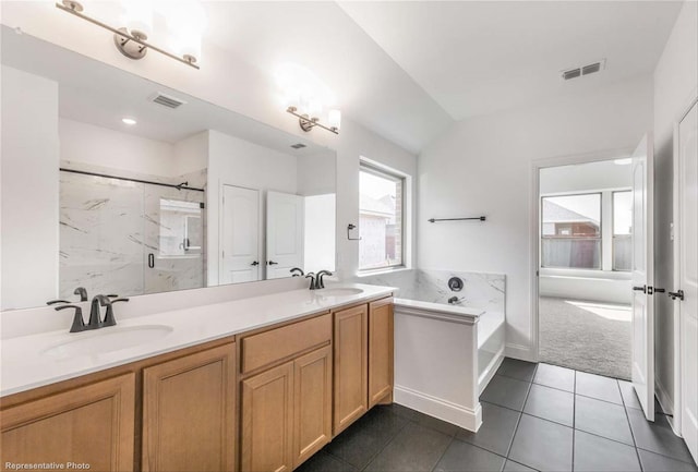 bathroom featuring tile patterned floors, vanity, and shower with separate bathtub