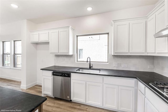 kitchen featuring sink, tasteful backsplash, light hardwood / wood-style flooring, stainless steel appliances, and white cabinets