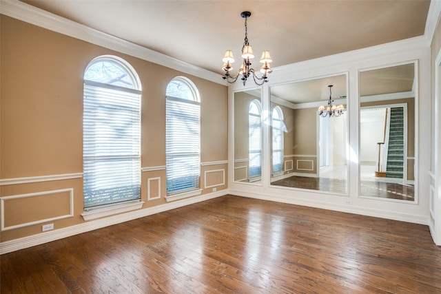 unfurnished dining area featuring dark hardwood / wood-style floors, ornamental molding, and an inviting chandelier